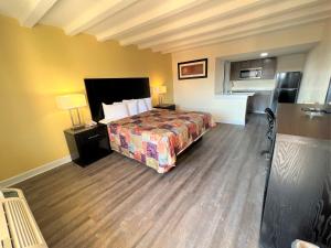 ニューポートニューズにあるJames River Inn & Suitesのベッド付きのウッドフロアの客室です。