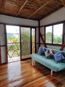 un soggiorno con divano blu e finestre di Cayo Ecovillage a Puerto Cayo