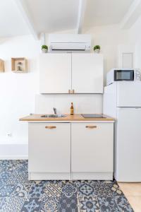 uma cozinha com armários brancos e um lavatório em Le Petit Panier Studio 3 Clim Vieux-Port - MaisonMars em Marselha