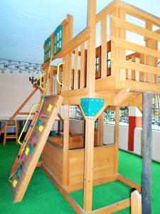 um conjunto de jogos de madeira com um escorrega num parque infantil em Hotel Zihua Caracol em Zihuatanejo