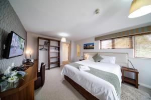 a bedroom with a bed and a flat screen tv at Abbeyfield Lodge in Stockton-on-Tees