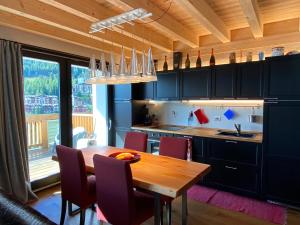 a kitchen with a wooden table and purple chairs at Chalet Ronchi - Foppolo Ski in Foppolo