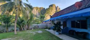 a blue house with palm trees in the background at La Belle Cliff View in Ao Nang Beach
