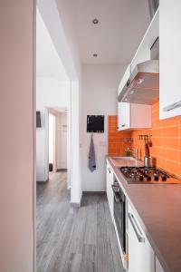 a kitchen with white cabinets and orange tiles at Appartamento a Piazza dell'Unità by Wonderful Italy in Bologna