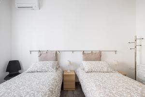 two beds sitting next to each other in a bedroom at Appartamento a Piazza dell'Unità by Wonderful Italy in Bologna