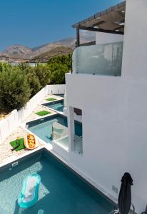 ein Pool neben einem weißen Gebäude in der Unterkunft SKYROS BLUE SUITES in Skyros