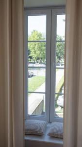 ventana con 2 almohadas sentadas en el alféizar de la ventana en Central Park Apartments, en Bjelovar