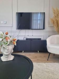 een woonkamer met een tafel met een vaas met bloemen erop bij Central Park Apartments in Bjelovar