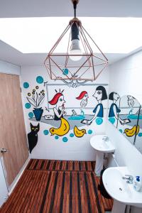 a bathroom with a mural on the wall at Hostal Copart in San Pedro de Atacama