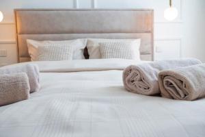 a white bed with towels on top of it at Central Park Apartments in Bjelovar