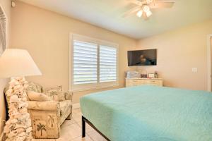 1 dormitorio con 1 cama, 1 silla y ventilador de techo en St Augustine Island Cottage - Walk to Beach, en St. Augustine