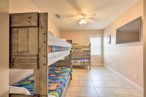 a bedroom with two bunk beds and a ceiling fan at St Augustine Island Cottage - Walk to Beach in Saint Augustine
