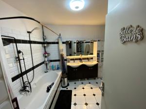 ein Badezimmer mit Badewanne, Waschbecken und Spiegel in der Unterkunft 1 Chambre chez l habitant, 1 à 4 pers, Park ext, TAXI VTC 6places disponibles in Auvernaux + 3 Fotos