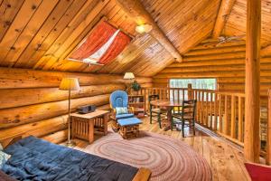 a log cabin living room with a bed and a table at Tranquil Mountain Cabin with Game Room and Fireplace! in Greer