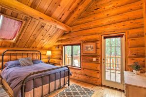 um quarto com uma cama num chalé de madeira em Tranquil Mountain Cabin with Game Room and Fireplace! em Greer
