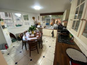 eine Küche mit einem Tisch und Stühlen darin in der Unterkunft 1 Chambre chez l habitant, 1 à 4 pers, Park ext, TAXI VTC 6places disponibles in Auvernaux