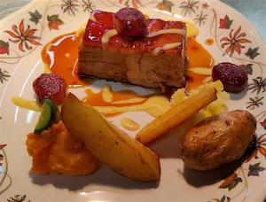 un plato de comida con un trozo de tarta y fruta en Locanda il Pomo d'Oro, en Torre Pellice