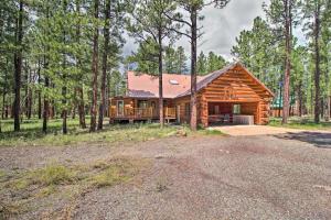 a log cabin in the middle of a forest at Tranquil Mountain Cabin with Game Room and Fireplace! in Greer