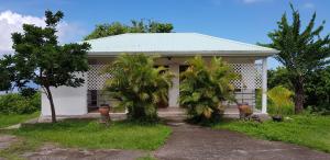 una casa con dos palmeras delante de ella en Paisible maison à Vieux-Habitants, en Vieux-Habitants