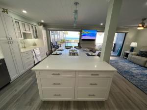 a kitchen and living room with a view of the ocean at Sunset Connection - Gulf Place in Holmes Beach