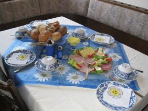 una mesa con un mantel azul y blanco con comida. en Landhaus Mast, en Baiersbronn