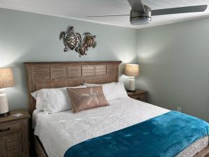 ein Schlafzimmer mit einem Bett und zwei Nachttischen und zwei Lampen in der Unterkunft Sunset Connection - Gulf Place in Holmes Beach