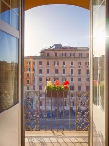 a window with a pot of flowers on a balcony at Sunny Guest House in Rome