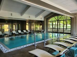 a large swimming pool with chairs in a building at Relais Sant'Uffizio Wellness & Spa in Cioccaro
