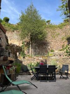 een tafel en stoelen voor een bakstenen muur bij Maison cosy en plein centre ville in Semur-en-Auxois
