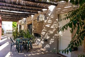 um pátio com uma mesa e cadeiras num edifício em Cabañas Parque Vistalba em Ciudad Lujan de Cuyo