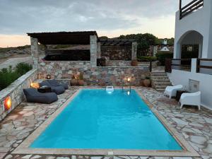 una piscina en un patio con una casa en Big Blue Villa, en Sounio