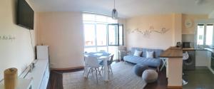 ein Wohnzimmer mit einem blauen Sofa und einem Tisch in der Unterkunft Apartamento con vistas al mar, playa de Carnota! in San Mamede de Carnota