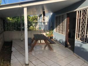 a patio with a wooden picnic table on a house at T2 à Convenance in Baie-Mahault