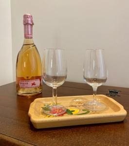 B&B Nonno Loreto في تشلانو: كأسين من النبيذ على لوح التقطيع مع زجاجة من النبيذ