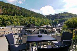 a table and chairs on a balcony with a view at Komfort-Fewo Schöner Platz am Rathaus in Willingen +27 photos
