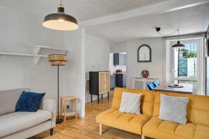 uma sala de estar com um sofá amarelo e uma cozinha em Finest Retreats - Poppy Cottage of Penzance em Penzance