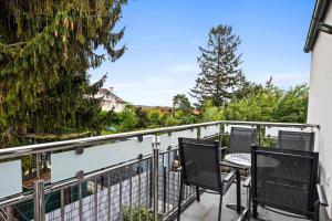 a balcony with two chairs and a table on it at Wienerberg-Apartments in Vienna