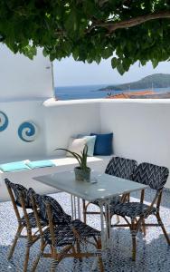 a white table and chairs with a table and a couch at Oikies Skiathos in Skiathos