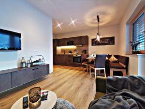 a living room and kitchen with a couch and a table at Apart Isabella in Schwendau