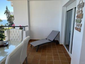a balcony with a glass table and a chair at MI CAPRICHO, Beach Front Apartment P14 3ºB in Mijas Costa