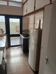 Il comprend une cuisine équipée d'un réfrigérateur blanc et d'une cuisinière. dans l'établissement Superbe appartement au centre de la capitale, à Rabat