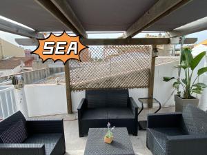 een patio met 2 stoelen en een tafel op een balkon bij Apartamentos Playa in Badalona