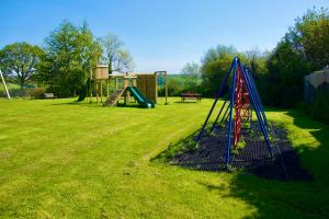a playground with a slide in a grass field at St Michaels Coach House in Crediton