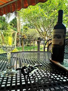 una bottiglia di vino seduta su un tavolo con un bicchiere di SOL Y SALSA bnb a Cuernavaca