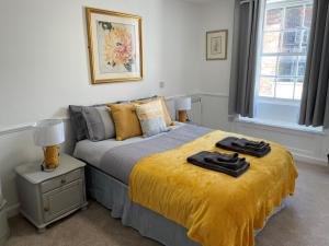 a bedroom with a bed with a yellow blanket at The Crown Fakenham in Fakenham