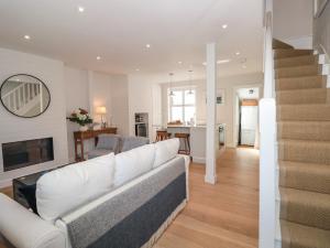 a living room with a white couch and a staircase at Marroy in Salcombe