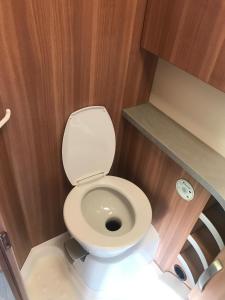 La petite salle de bains est pourvue de toilettes et de murs en bois. dans l'établissement קרוואן על החוף, à Eilat