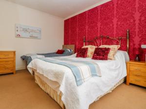a bedroom with two beds with red wallpaper at Dutch Blues in Malton