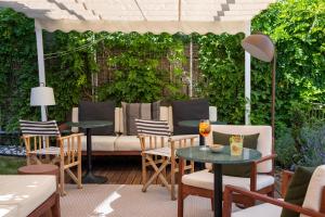 a patio with a couch and tables and chairs at Fontinha Porto, Trademark Collection by Wyndham in Porto