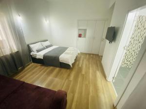 a bedroom with a bed and a wooden floor at Secret Garden Guest House 02 in Famagusta